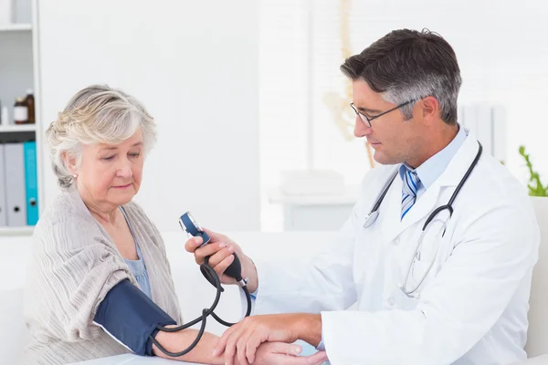 Doctor checking patients blood pressure