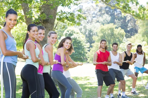 Fitness group playing tug of war