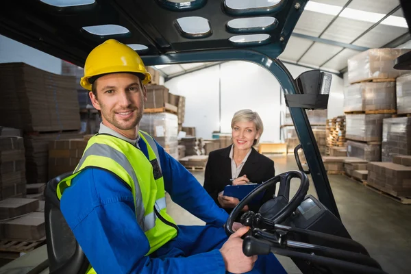 Warehouse worker and manager smiling