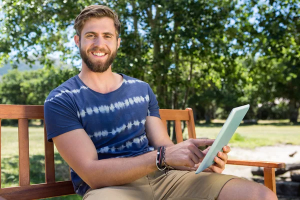 Man using tablet on park bench