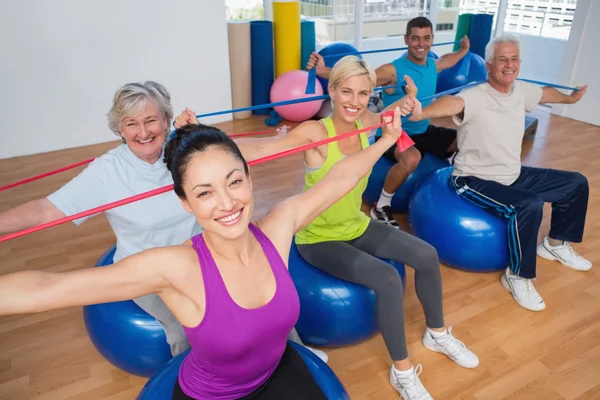 People exercising with resistance bands in gym