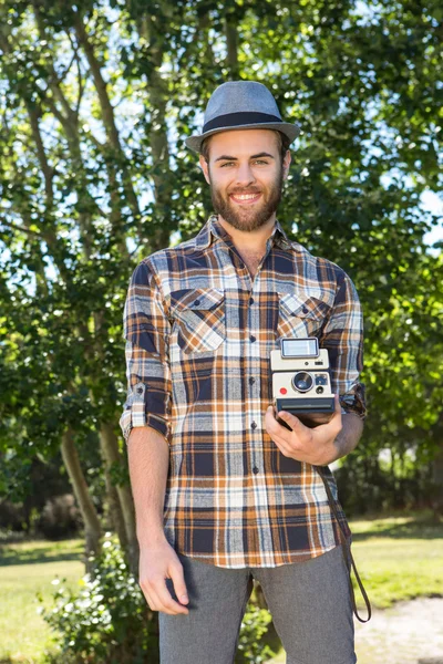 Handsome hipster using vintage camera