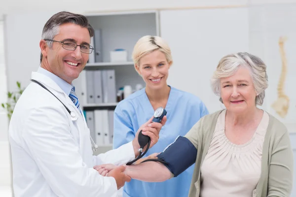 Doctor checking patients blood pressure