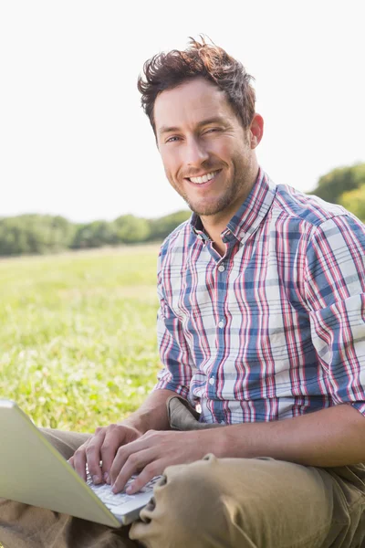 Man using laptop in countryside