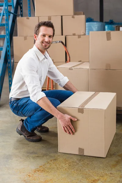 Smiling warehouse manager with box