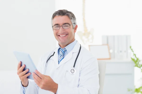 Confident male doctor using tablet