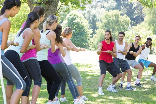 Fitness group playing tug of war