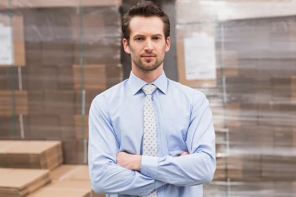 Manager with arms crossed in warehouse