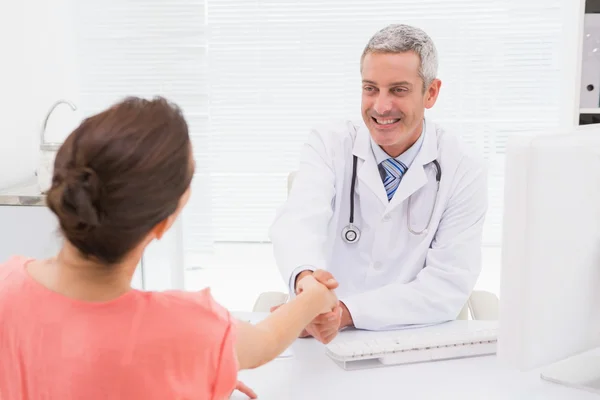 Happy doctor handshake at his patient