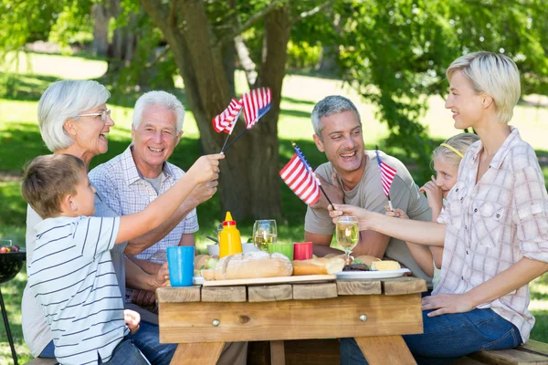 Family having picnic and holding american flag