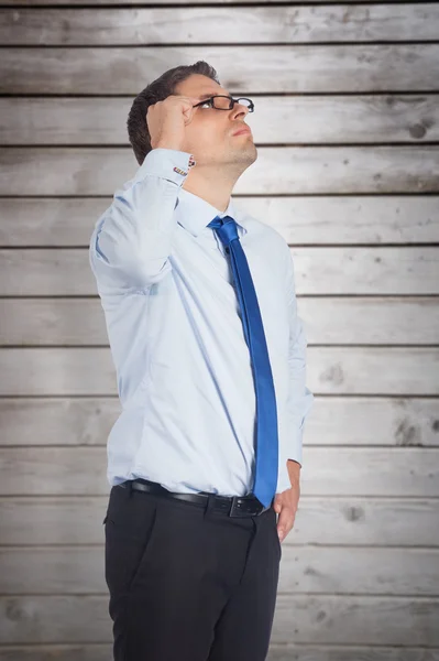 Thinking businessman tilting glasses