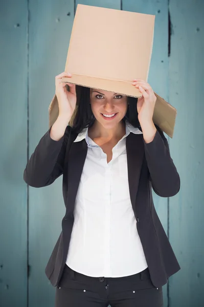 Businesswoman lifting box off head