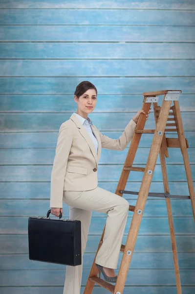 Businesswoman climbing career ladder with briefcase