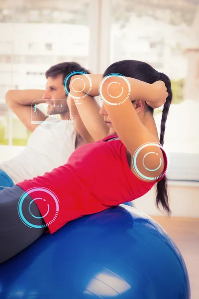 Fit young couple exercising on fitness balls