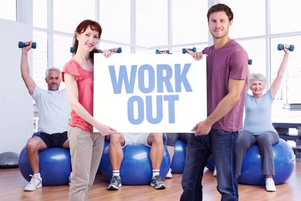 Couple holding sign against work out