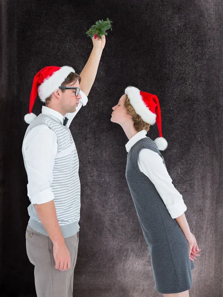 Geeky hipster kissing under mistletoe