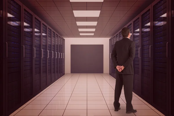 Businessman against server room with towers