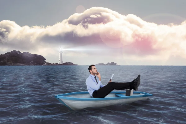 Businessman in boat with tablet pc against calm sea