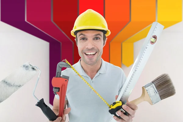 Happy worker holding various equipment
