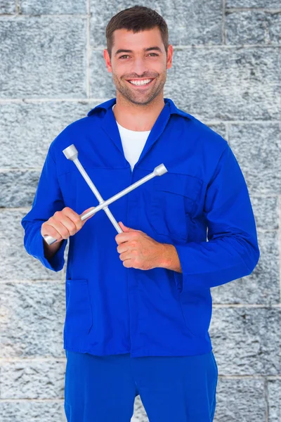 Male mechanic holding lug wrench