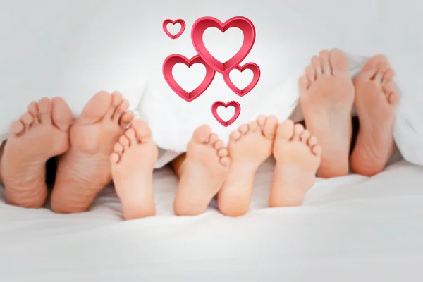 Family on the bed at home with their feet