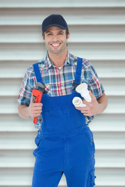 Plumber holding monkey wrench and sink pipe