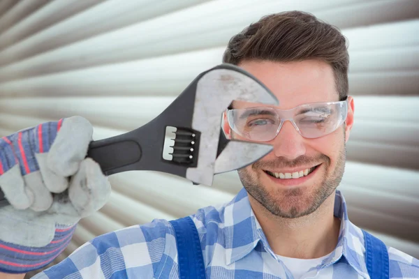 Confident repairman holding wrench