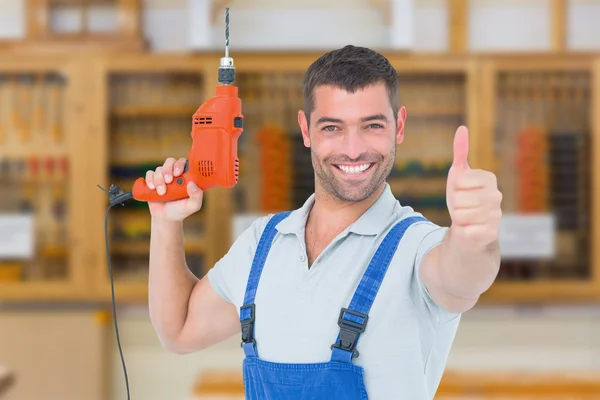 Smiling repairman with drill machine
