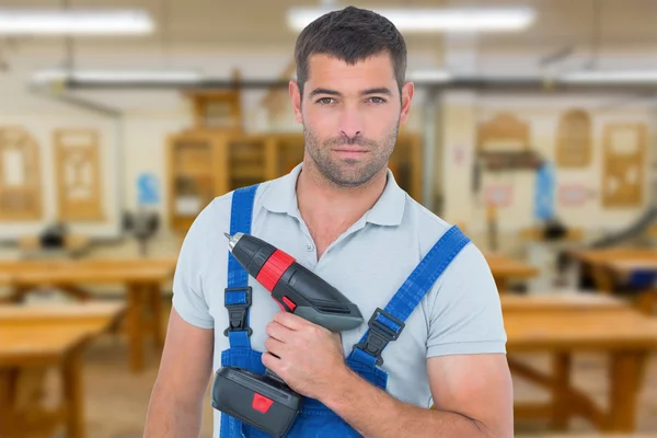 Confident carpenter holding power drill