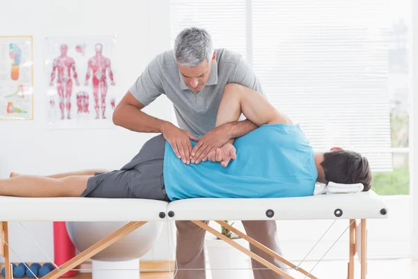 Doctor examining man back