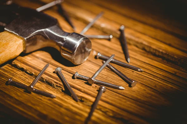 Hammer and nails laid out on table