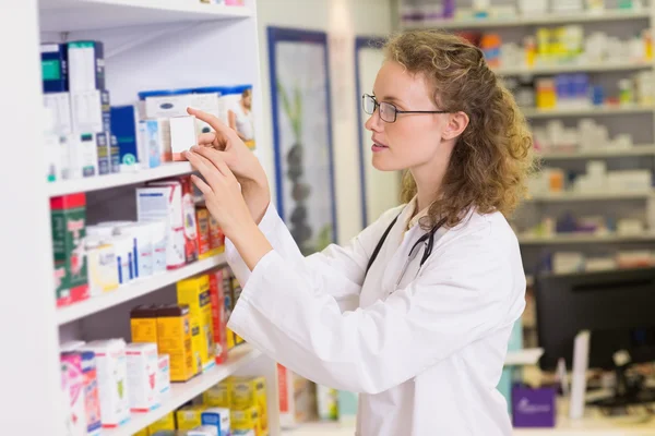Pharmacist taking jar from shelf
