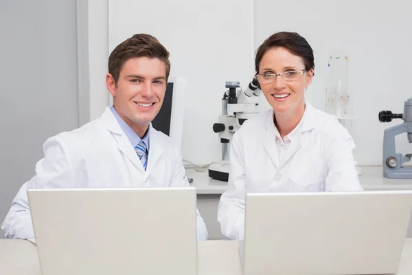 Scientists working with laptop and smiling