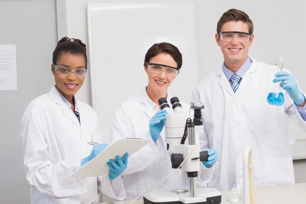 Scientists working with microscope and beaker