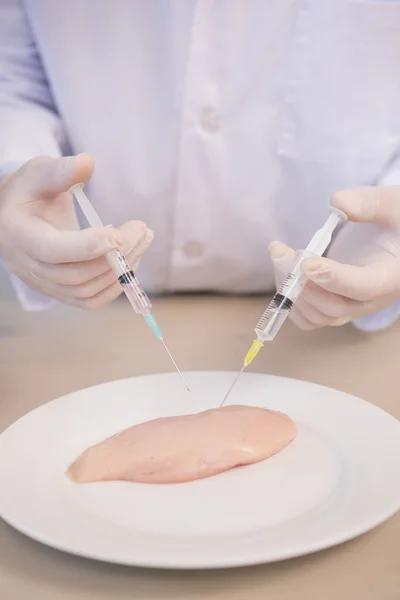 Scientist injecting piece of meat