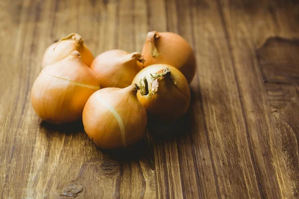 Fresh onions on wooden background