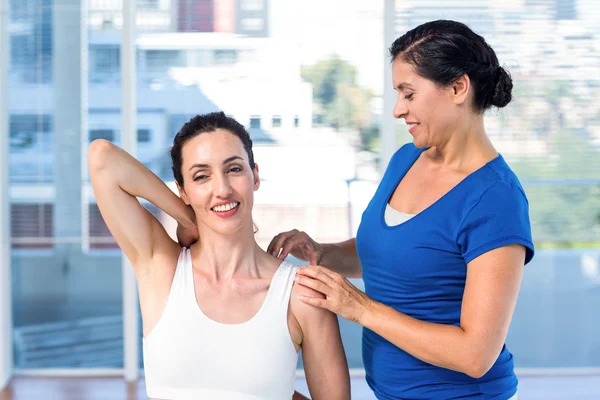 Woman stretching her arm with her therapist