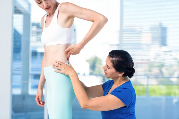 Therapist examining her patients back