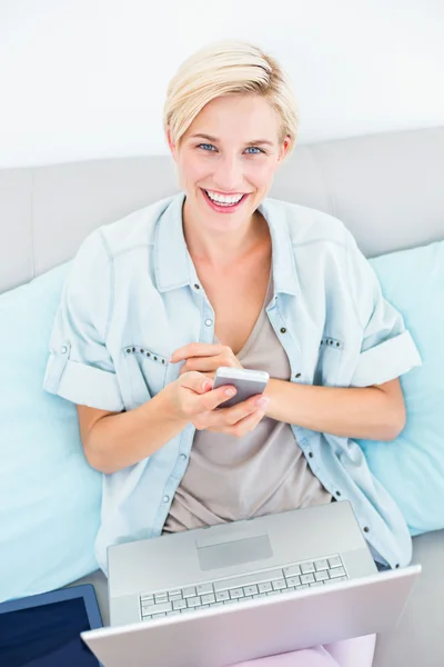 Woman using laptop and mobile phone