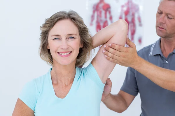 Woman stretching her arms with her doctor
