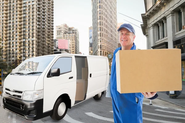 Happy delivery man showing cardboard box