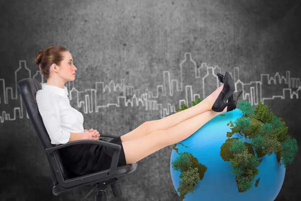 Businesswoman sitting on swivel chair with feet up