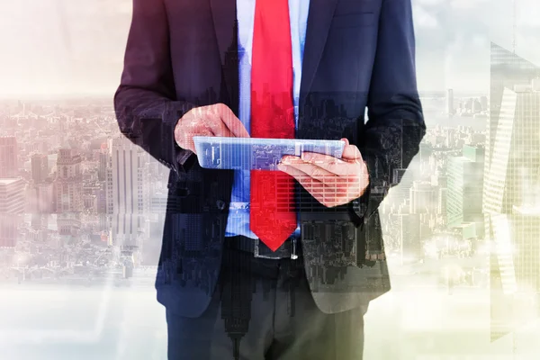 Composite image of businessman scrolling on his digital tablet