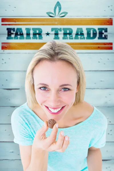 Composite image of smiling blonde holding box of chocolates