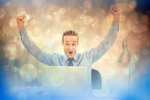 Cheering businessman at laptop