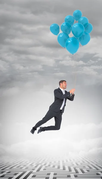 Businessman flying with balloons