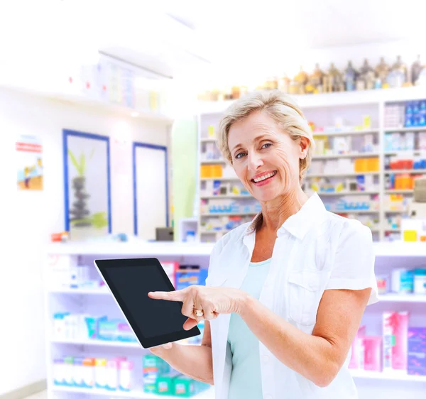 Happy mature woman pointing to tablet pc