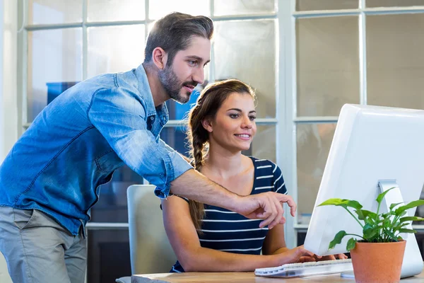 Smiling colleagues working together on computer