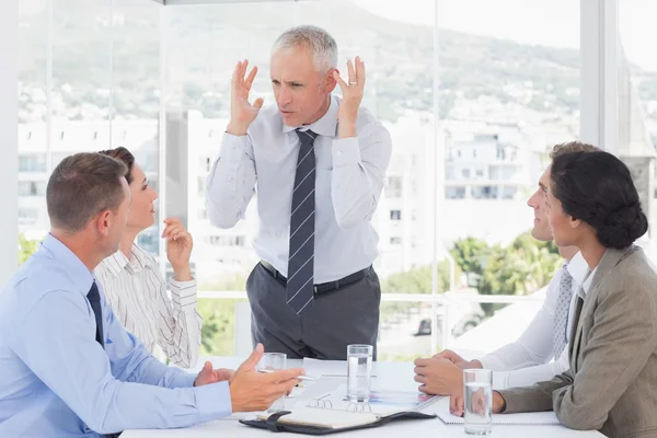 Irritated businessman talking to his team