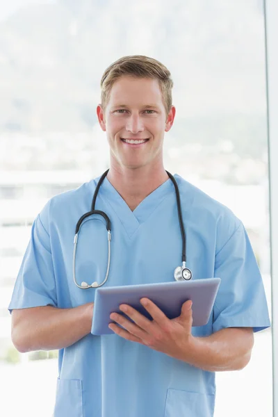 Doctor writing on clipboard beside windows